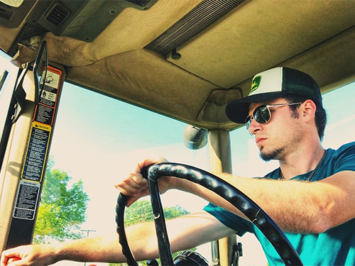 Dakota Davidson driving his tractor